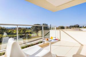 a balcony with white furniture and a view of the water at Laguna - Vilamoura in Vilamoura