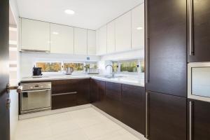 a kitchen with brown cabinets and stainless steel appliances at Laguna - Vilamoura in Vilamoura