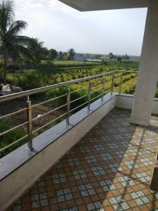 a walkway with a fence and a view of a field at Nisarg Farm Villa in Shirdi