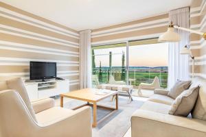 a living room with a couch and a tv and a table at Laguna - Vilamoura in Vilamoura