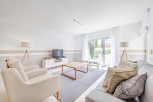 a white living room with a couch and a table at Laguna - Vilamoura in Vilamoura