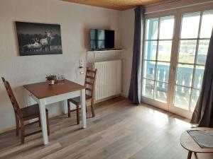 comedor con mesa, sillas y ventana en Ferienwohnung Reinbold, en Durbach