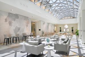 a lobby with chairs and tables and a map on the wall at Arjaan by Rotana - Dubai Media City in Dubai