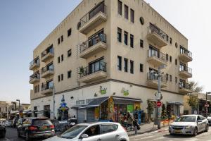 ein hohes Gebäude mit davor geparkt in der Unterkunft 2 Bedrooms Best Location in Jaffa Yafo Near Jaffa Clock Tower in Tel Aviv