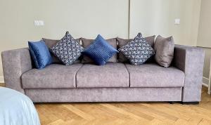 a gray couch with blue pillows on it at Appartement d exception 100m2 avec Parking - Centre historique in Chambéry