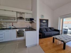 a kitchen and a living room with a couch at SUNNY BALCONY TERRACE Apartment in Novalja