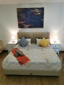 a bedroom with a bed with two tables and two lamps at Apple Home 2 at Menara Simfoni, King Size Bed, Cheras, Nexflix, Wifi, Parking in Seri Kembangan