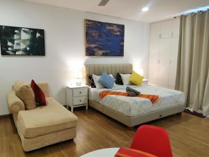 a bedroom with a bed and a couch and a chair at Apple Home 2 at Menara Simfoni, King Size Bed, Cheras, Nexflix, Wifi, Parking in Seri Kembangan