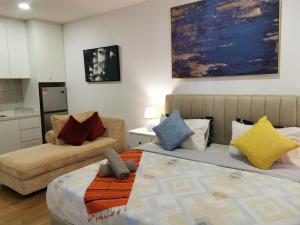 a living room with two beds and a couch at Apple Home 2 at Menara Simfoni, King Size Bed, Cheras, Nexflix, Wifi, Parking in Seri Kembangan