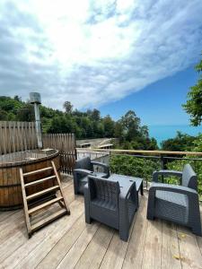 een terras met stoelen en een tafel en uitzicht op de oceaan bij Glamping Village in Sarpi