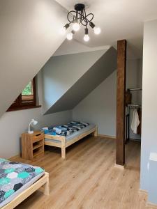 sypialnia z 2 łóżkami na poddaszu w obiekcie Świerkowe Domki Cisna w Cisnej