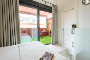 sypialnia z łóżkiem i dużym oknem w obiekcie Guardamino Dúplex Suite Apartment w Sewilli