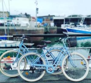 迪耶普Bel appartement vue mer centre-ville, face plage的两辆自行车停放在码头旁边,船屋