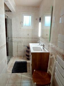 y baño blanco con lavabo y ducha. en gite a st germain sur ay, en Bretteville-sur-Ay