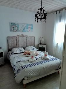 a bedroom with a bed with towels and a chandelier at gite a st germain sur ay in Bretteville-sur-Ay