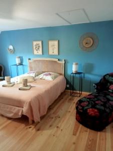een slaapkamer met een bed en een blauwe muur bij chambre k au domaine du mont scolan in Montgardon
