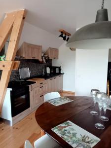 een keuken met een tafel met wijnglazen erop bij chambre k au domaine du mont scolan in Montgardon