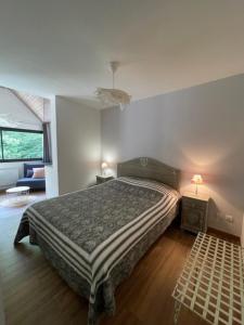 a bedroom with a bed and a night stand with a lamp at L'AUBERGE DE LA GOUTILLE in Capvern