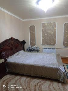 um quarto com uma cama e um lustre em Милый дом em Tokmok