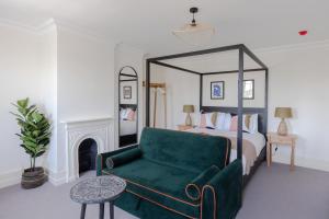 een slaapkamer met een bed en een groene bank bij Redcliffe Parade No.9 I Your Apartment in Bristol