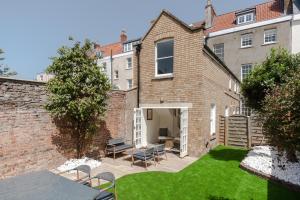 a backyard with a brick building and a lawn at Redcliffe Parade No.9 I Your Apartment in Bristol