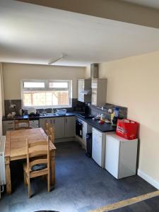 a kitchen with a wooden table and a table and a dining room at Aegir House in Gainsborough