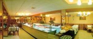 ein Restaurant mit einer langen Theke mit Tischen und Stühlen in der Unterkunft HOTEL CONTINENTAL in Calella + 17 Fotos