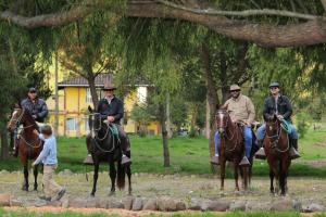 un groupe de personnes à cheval dans un parc dans l'établissement Hacienda San Juan de La Vega, à Otavalo