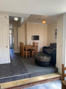 ein Wohnzimmer mit einem Sofa, einem Tisch und einem Stuhl in der Unterkunft Aegir House in Gainsborough