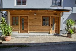 a house with a wooden garage with two potted plants at Keramikhaus Gmunden in Gmunden