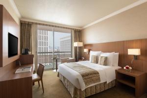 a hotel room with a large bed and a large window at Treffen House Doha - next to Msheireb Metro Station and Souq Waqif in Doha