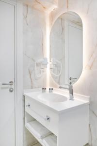 uma casa de banho branca com um lavatório e um espelho em Silvana Hotel em Istambul