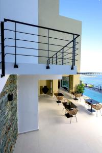 普洛馬里翁的住宿－Irini Design Apartments，一座配有桌椅的建筑中的玻璃楼梯