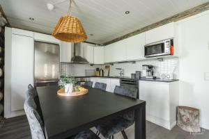 a kitchen with a black table and chairs at Holiday In Lapland - Riekkopolku 2 B in Levi