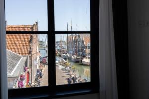 a window with a view of a canal with boats at Hotel Monnickendam in Monnickendam