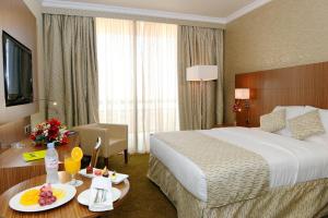 um quarto de hotel com uma cama e uma mesa com comida em Treffen House Doha - next to Msheireb Metro Station and Souq Waqif em Doha