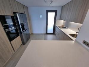 a kitchen with a refrigerator and a counter top at Sidi Luxury (Beach & Golf) in Alicante
