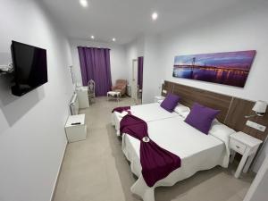 um quarto de hotel com duas camas e uma televisão de ecrã plano em Casa Rural "Laplaza23" em Herrera del Duque