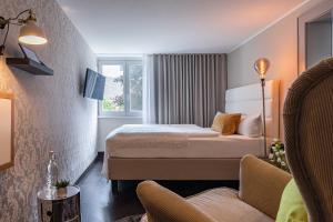 ein Hotelzimmer mit 2 Betten und einem Sofa in der Unterkunft Ganter Hotel & Restaurant Mohren in Reichenau