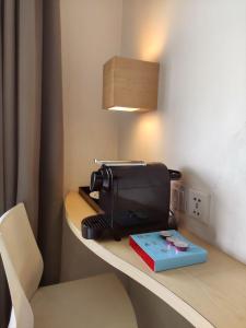 a toaster sitting on a counter with a book on it at Liberta Hotel Kemang in Jakarta