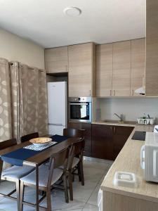 una cucina con tavolo, sedie e frigorifero di Ikaria Village Maisonette 10 a Klorakas