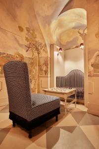 ein Wohnzimmer mit einem Stuhl und einem Tisch in der Unterkunft The Leo Grand in Wien