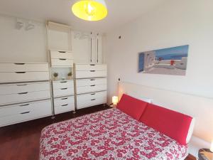 sypialnia z czerwonym łóżkiem i białymi komodami w obiekcie Parco Dora View Apartment w Turynie