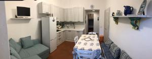 uma pequena cozinha com uma mesa e um frigorífico em Il gioiello di Orbetello em Orbetello