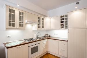 uma cozinha branca com armários brancos e um lavatório em Padova Santa Croce Apartment em Pádua