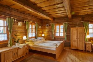 ein Schlafzimmer mit einem großen Bett in einem Blockhaus in der Unterkunft Volarská roubenka in Volary