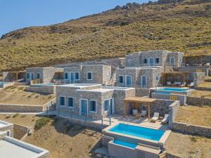 an aerial view of a stone house with two swimming pools at Nisides Suites in Livadi Astypalaias