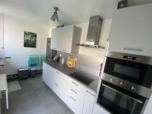 a kitchen with white cabinets and a stove top oven at Chambre privée face à la gare in Tarbes