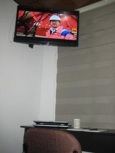 TV de pantalla plana colgada en la pared en Hotel Casa Santa Marta, en Bogotá
