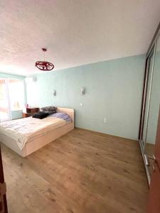 Un dormitorio con una cama y una lámpara de araña en Луксозен апартамент в сърцето на Сандански, en Sandanski